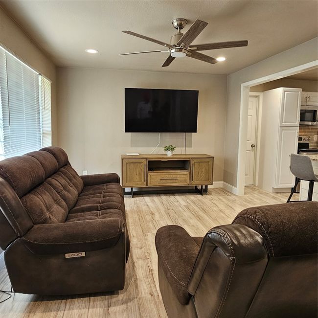 Living room with a ceiling fan, light wood-style floors, recessed lighting, and baseboards | Image 8