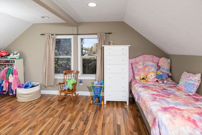 Bedroom with lofted ceiling, dark hardwood / wood-style floors, and a textured ceiling | Image 24