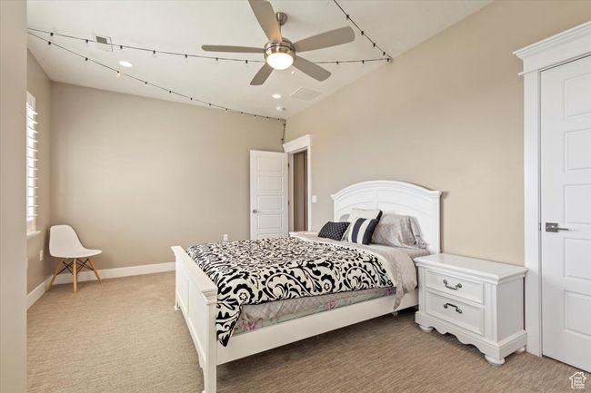 Bedroom with light carpet, baseboards, and ceiling fan | Image 24