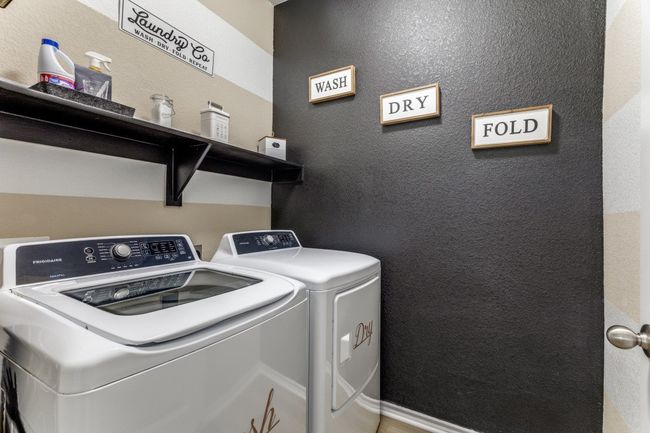 Laundry area featuring washer and clothes dryer and a textured wall | Image 33