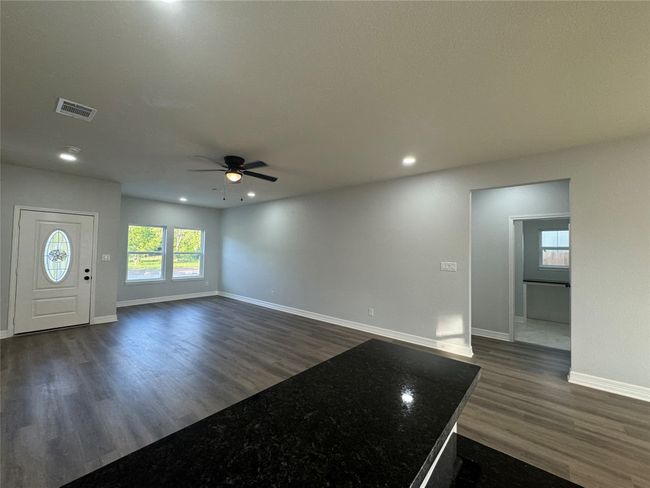 Unfurnished living room featuring a ceiling fan, dark wood-style flooring, and recessed lighting | Image 12