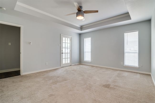 Primary bedroom with tray ceiling and attached bonus room with French door. | Image 16