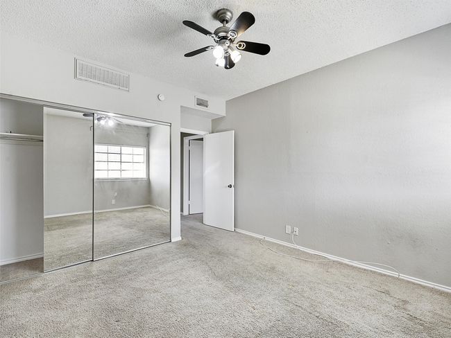 Bedroom with carpet & mirrored closet. | Image 28