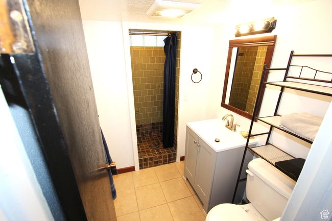 Bathroom with vanity, a tile shower, and tile patterned floors | Image 27