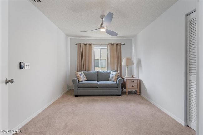 Living room featuring light carpet, baseboards, a textured ceiling, and a ceiling fan | Image 13