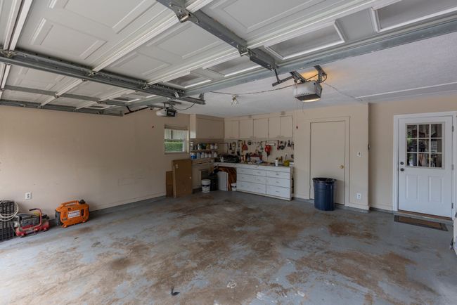 Garage with a garage door opener and a workshop area | Image 39
