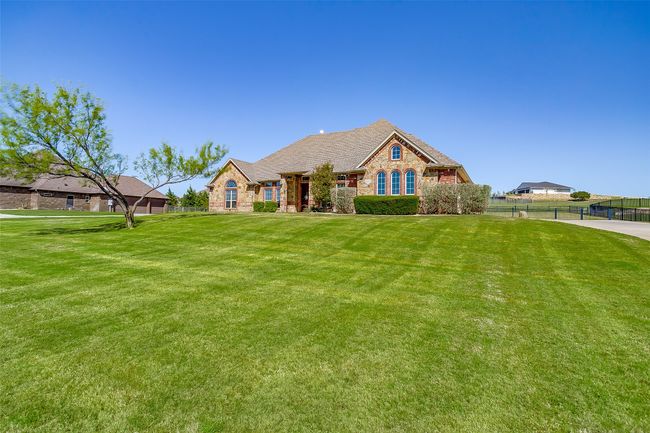 View of front of home featuring brick siding, a front lawn, fence, and stone siding | Image 29