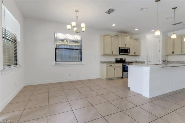 Kitchen with stainless steel appliances, plenty of natural light, a chandelier, cream cabinetry, and recessed lighting | Image 21