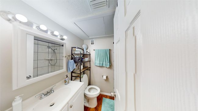 Full bath with vanity, toilet, walk in shower, visible vents, and wood finished floors | Image 11