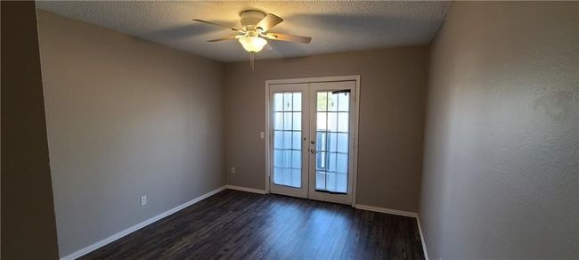 Spare room featuring french doors, dark wood finished floors, a ceiling fan, and a textured ceiling | Image 6