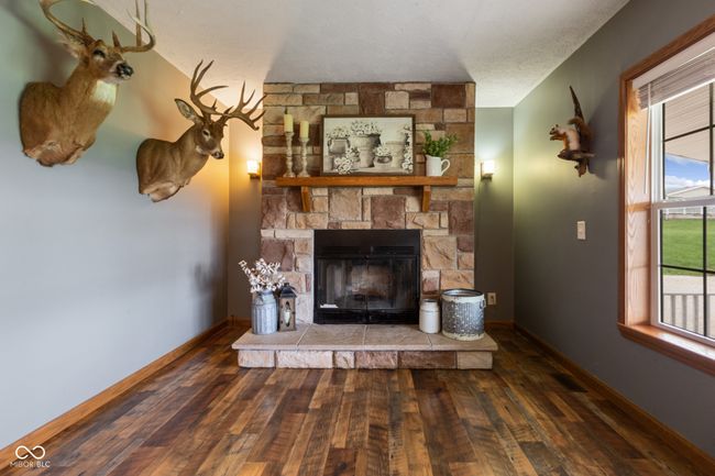 unfurnished living room featuring a fireplace, hardwood / wood-style flooring, and baseboards | Image 10