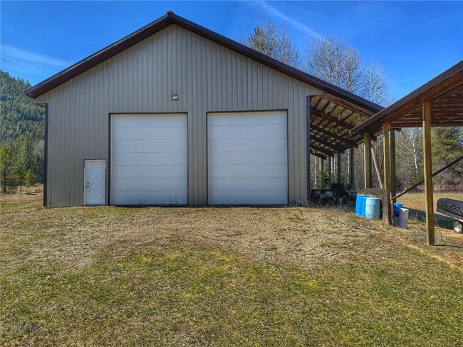 Rear view of property with a yard, metal roof, and covered porch | Image 50