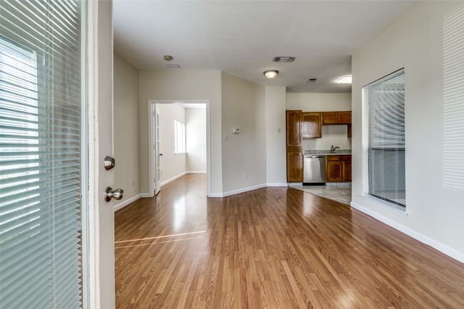 Unfurnished living room featuring a sink, baseboards, light wood-style floors, and visible vents | Image 5