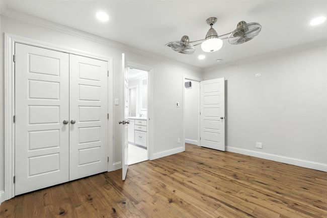 Unfurnished bedroom with wood finished floors, ornamental molding, recessed lighting, ensuite bath, and a closet | Image 27
