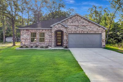 View of front facade with a garage and a front yard | Image 1