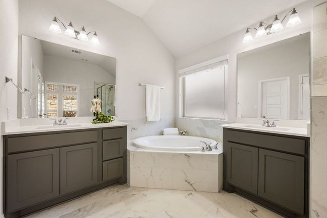Bathroom featuring vaulted ceiling, a stall shower, a garden tub, and a sink | Image 21