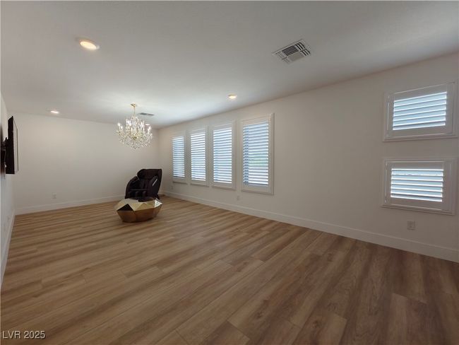 Empty room with recessed lighting, light wood-style flooring, a chandelier, baseboards, and visible vents | Image 26