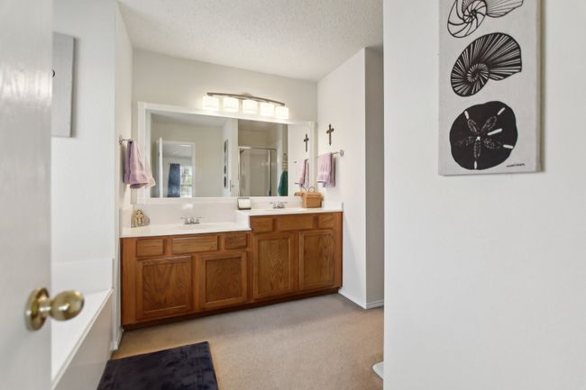 Bathroom with double vanity, a sink, a shower stall, and a textured ceiling | Image 20