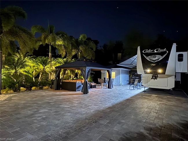 Pool at night featuring a gazebo and a patio | Image 14