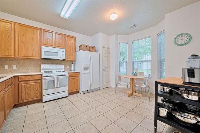 Entire wall of kitchen windows overlooking the gorgeous mature front yard trees. | Image 11