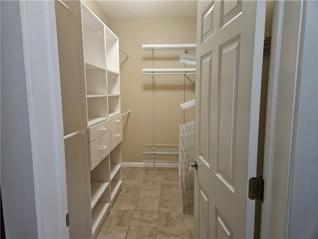 Spacious closet with light tile patterned floors | Image 15