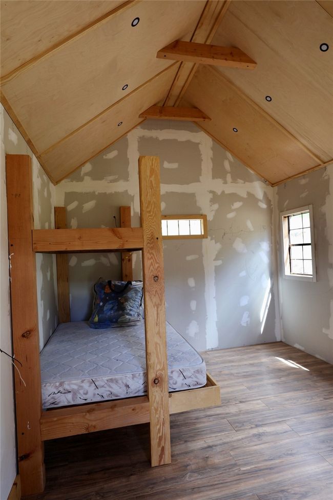 Unfurnished bedroom with wood finished floors | Image 13