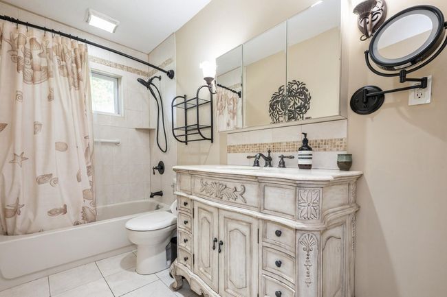 Full Bathroom with shower / tub combo, vanity, backsplash, and tile patterned flooring | Image 13