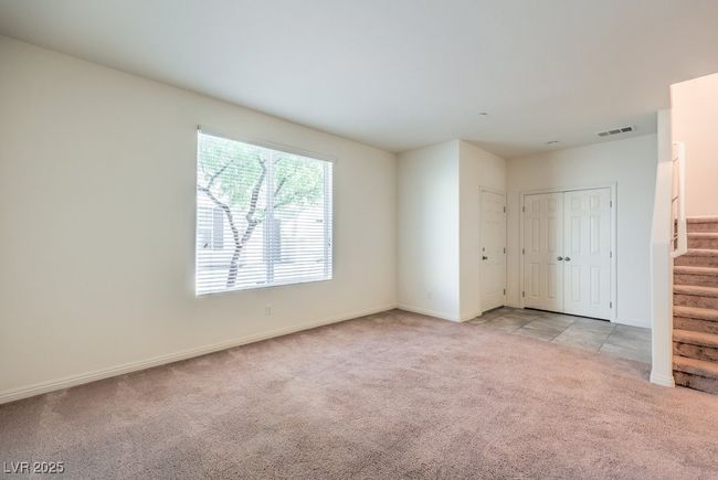 Unfurnished room with baseboards, stairway, visible vents, and light colored carpet | Image 12