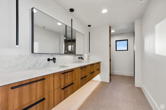 Bathroom with visible vents, baseboards, a sink, and backsplash | Image 24