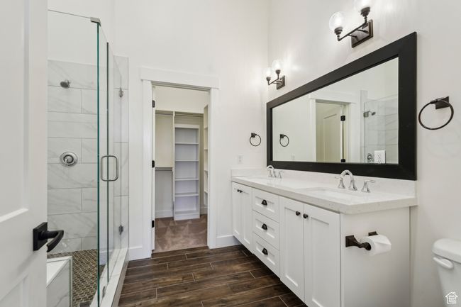 Full bathroom with wood finish floors, a stall shower, double vanity, and a sink | Image 27