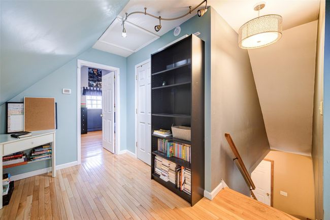 Upstairs landing space with baseboards, vaulted ceiling, hardwood / wood-style flooring. | Image 25