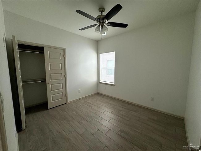Unfurnished bedroom featuring ceiling fan, a closet, baseboards, and wood finished floors | Image 9