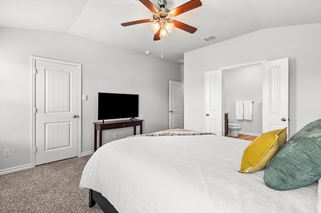 Bedroom with vaulted ceiling, ensuite bath, and a ceiling fan | Image 24