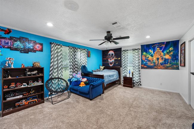 Carpeted bedroom with a textured ceiling, ceiling fan, and recessed lighting | Image 17