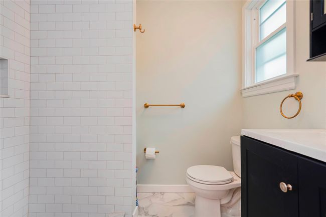 Bathroom with vanity, toilet, marble finish floor, walk in shower, and baseboards | Image 25