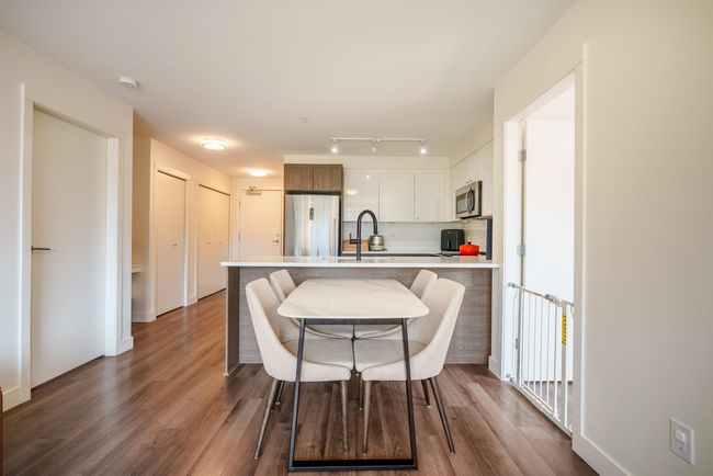Kitchen featuring appliances with stainless steel finishes, light countertops, a peninsula, decorative backsplash, and wood finished floors | Image 10