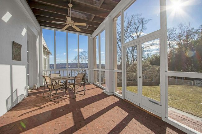 Sunroom with ceiling fan, a wealth of natural light, and a water view | Image 6
