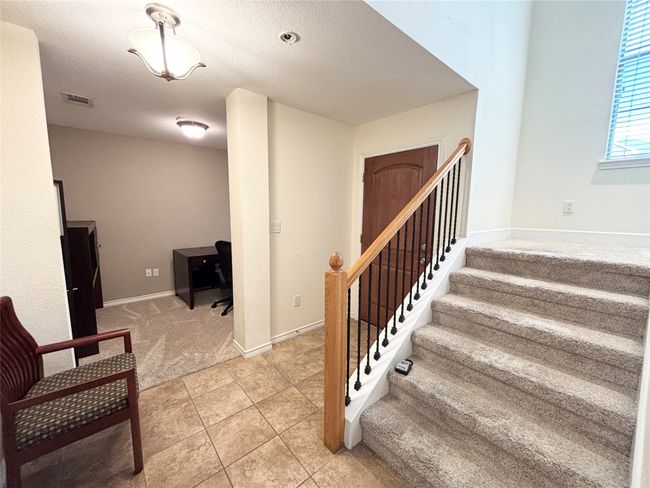 Stairs with tile patterned floors, carpet floors, baseboards, and a textured ceiling | Image 4