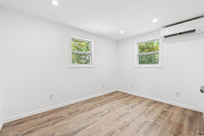 Spare room with a wall unit AC, recessed lighting, healthy amount of natural light, and wood finished floors | Image 12