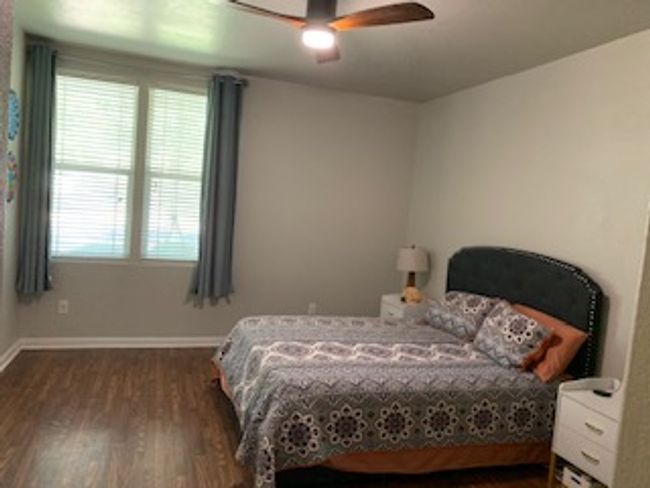 Bedroom with dark wood-style floors, baseboards, and ceiling fan | Image 16