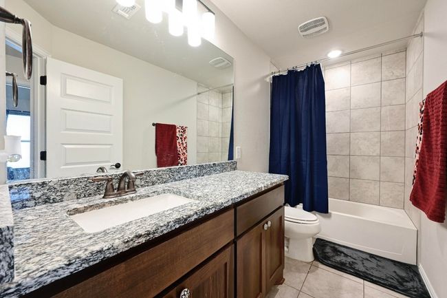3rd Full bath featuring tile patterned floors, vanity, and shower / tub combo with curtain | Image 25
