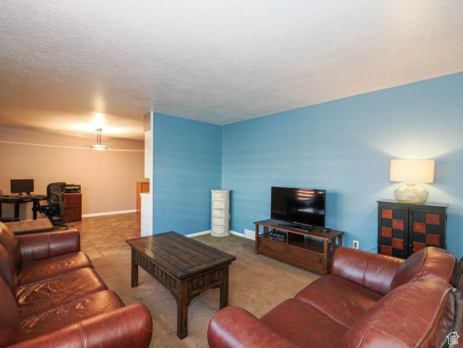 Living room featuring an office area, carpet flooring, baseboards, and a textured ceiling | Image 6