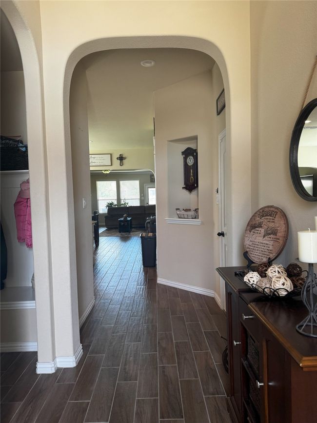 Hall with dark wood-style flooring and arched walkways | Image 25