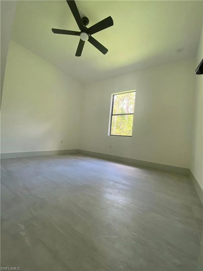 Unfurnished room with concrete flooring, ceiling fan, and baseboards | Image 13