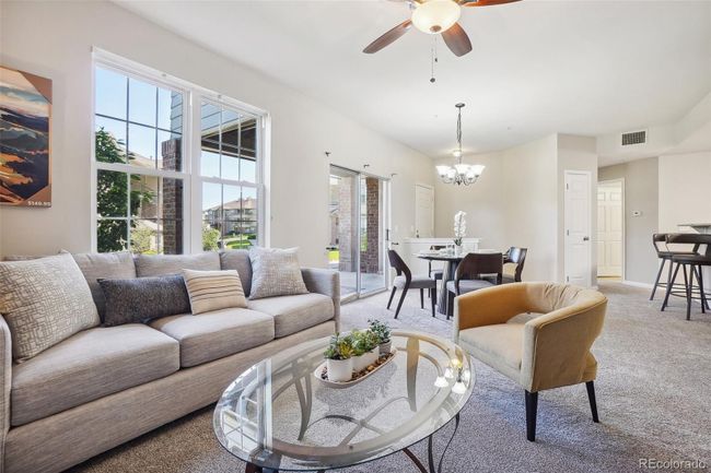 View from the living room looking back towards the dining area, entry and kitchen breakfast bar. | Image 9