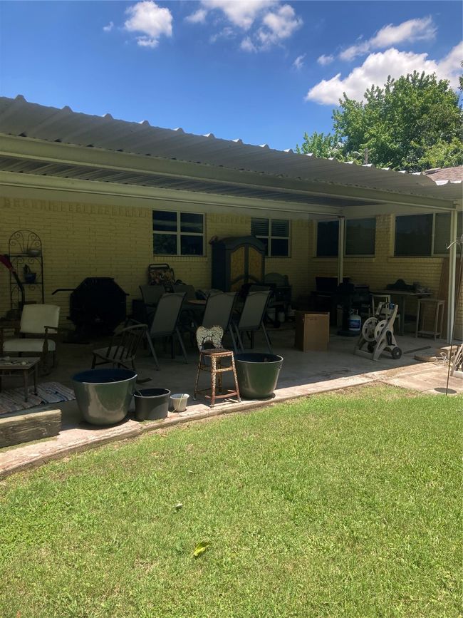 Rear view of property with a large patio, brick siding, and a yard | Image 7