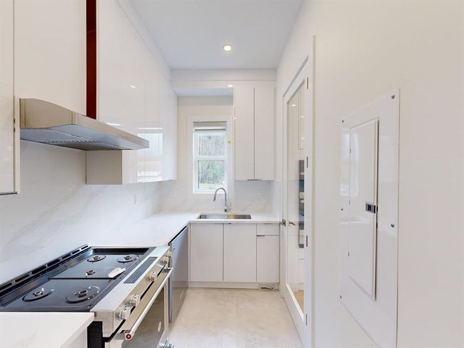 Kitchen with appliances with stainless steel finishes, ventilation hood, modern cabinets, white cabinets, and recessed lighting | Image 5