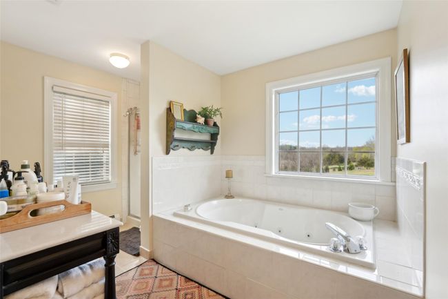 Carpeted bedroom with baseboards, a baseboard radiator, and multiple windows | Image 32