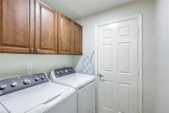 Laundry room featuring washing machine and clothes dryer and cabinet space | Image 15