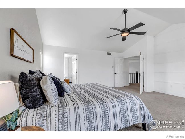 Double entry doors, custom wood accent wall, and vaulted ceilings in primary bedroom! | Image 21